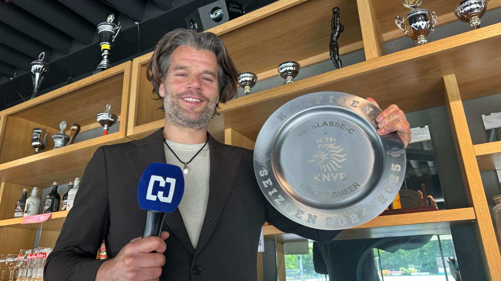 NH-presentator Erik-Jan Brinkman met de schaal