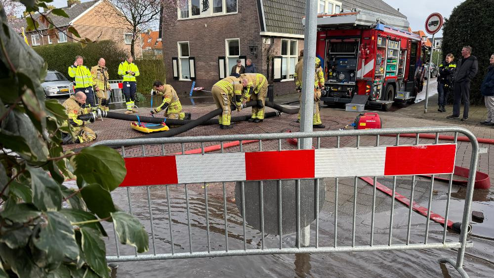 Straat in Naarden staat blank, brandweer ter plaatse om water af te pompen